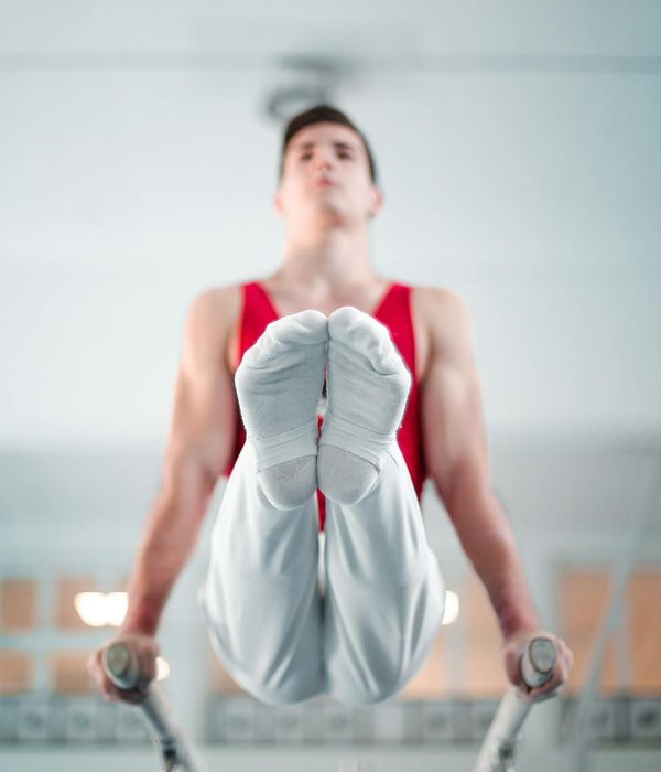 Man performing a controlled strength exercise in a modern gym.